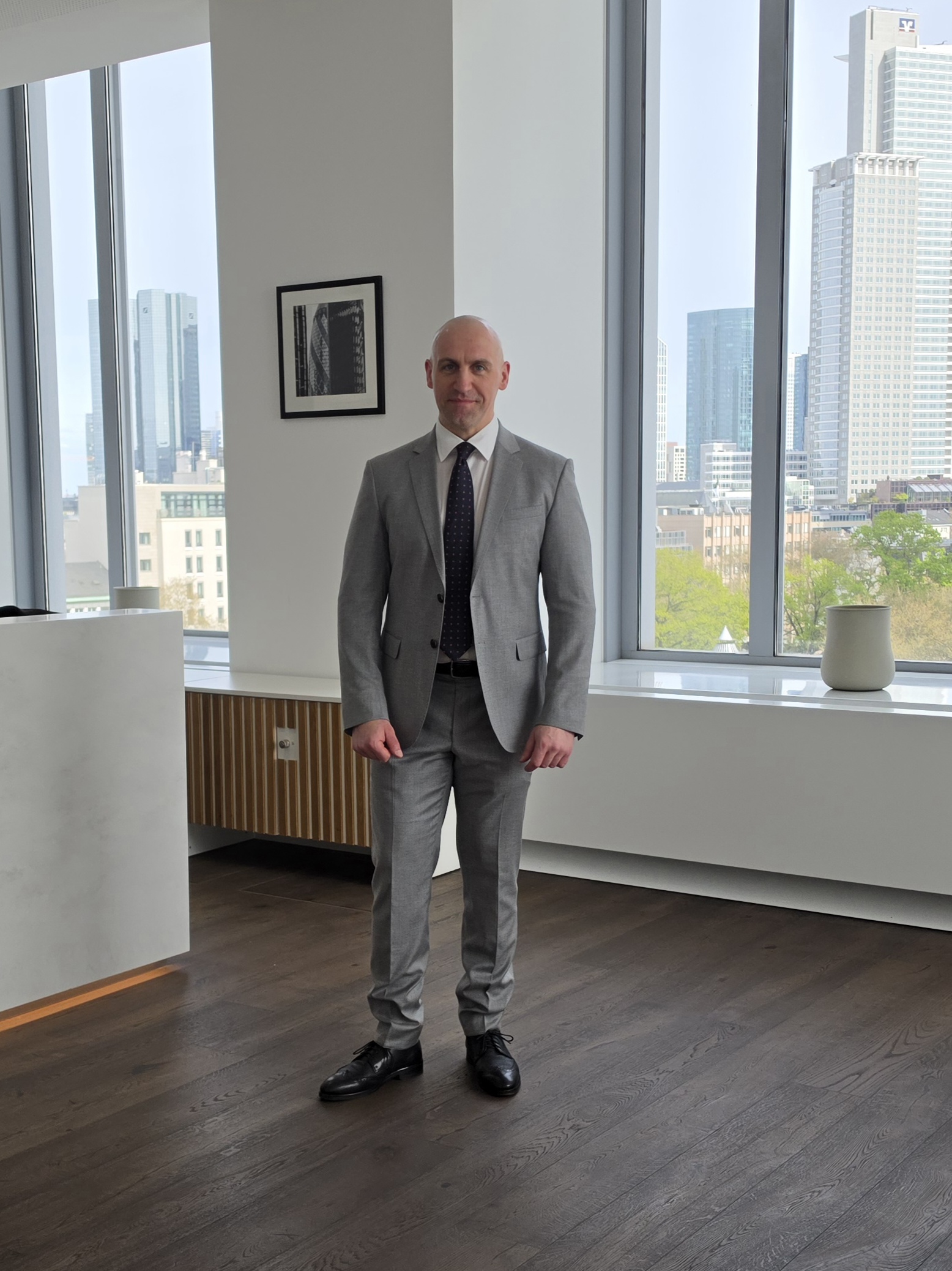 Ronny Kazyska vor moderner Architektur zum Grundsatz Risiko im Immobilienmarkt.