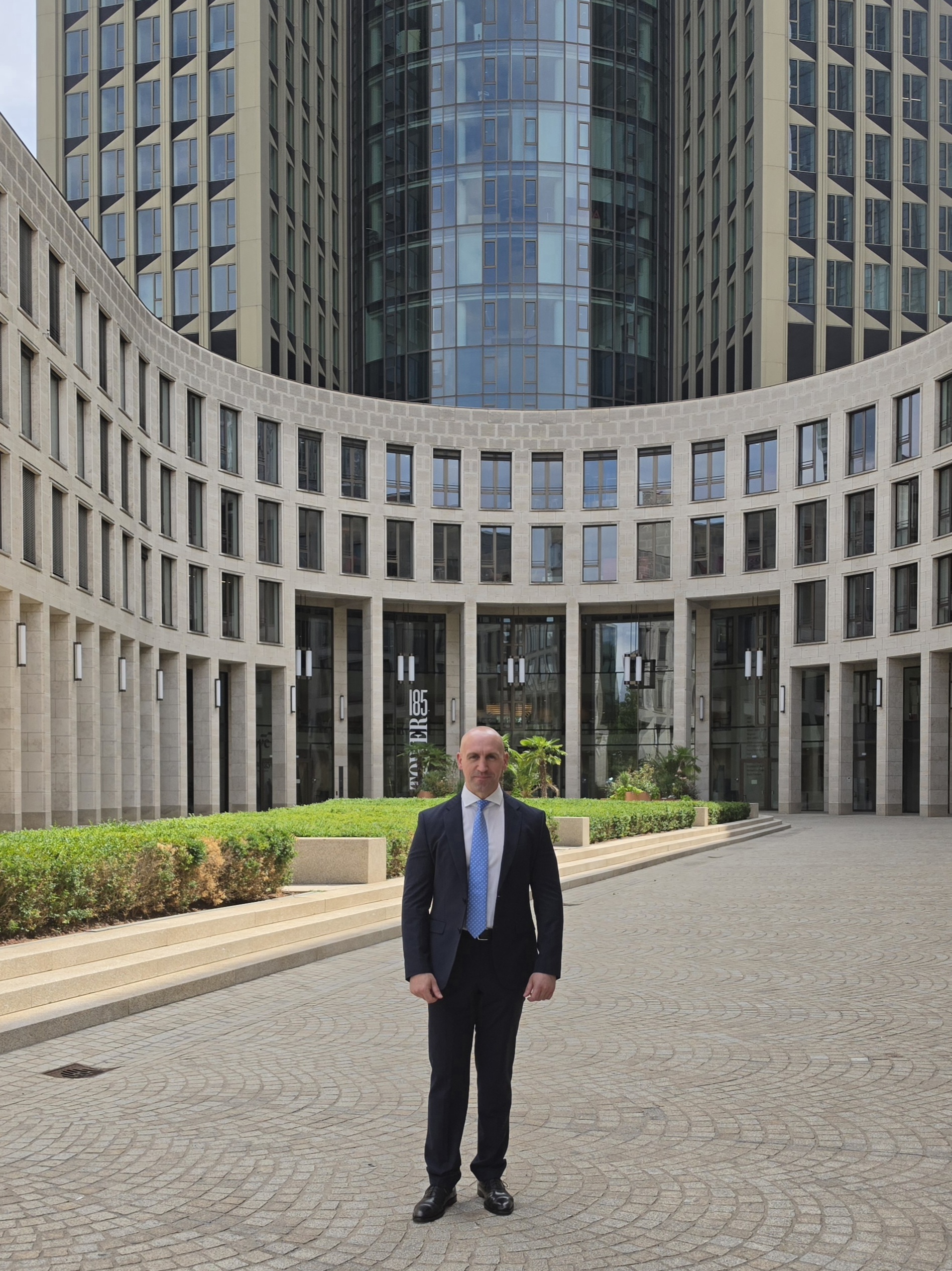 Ronny Kazyska vor moderner Büroarchitektur in Frankfurt am Main zum Grundsatz Ertragsqualität bei Investmentimmobilien.