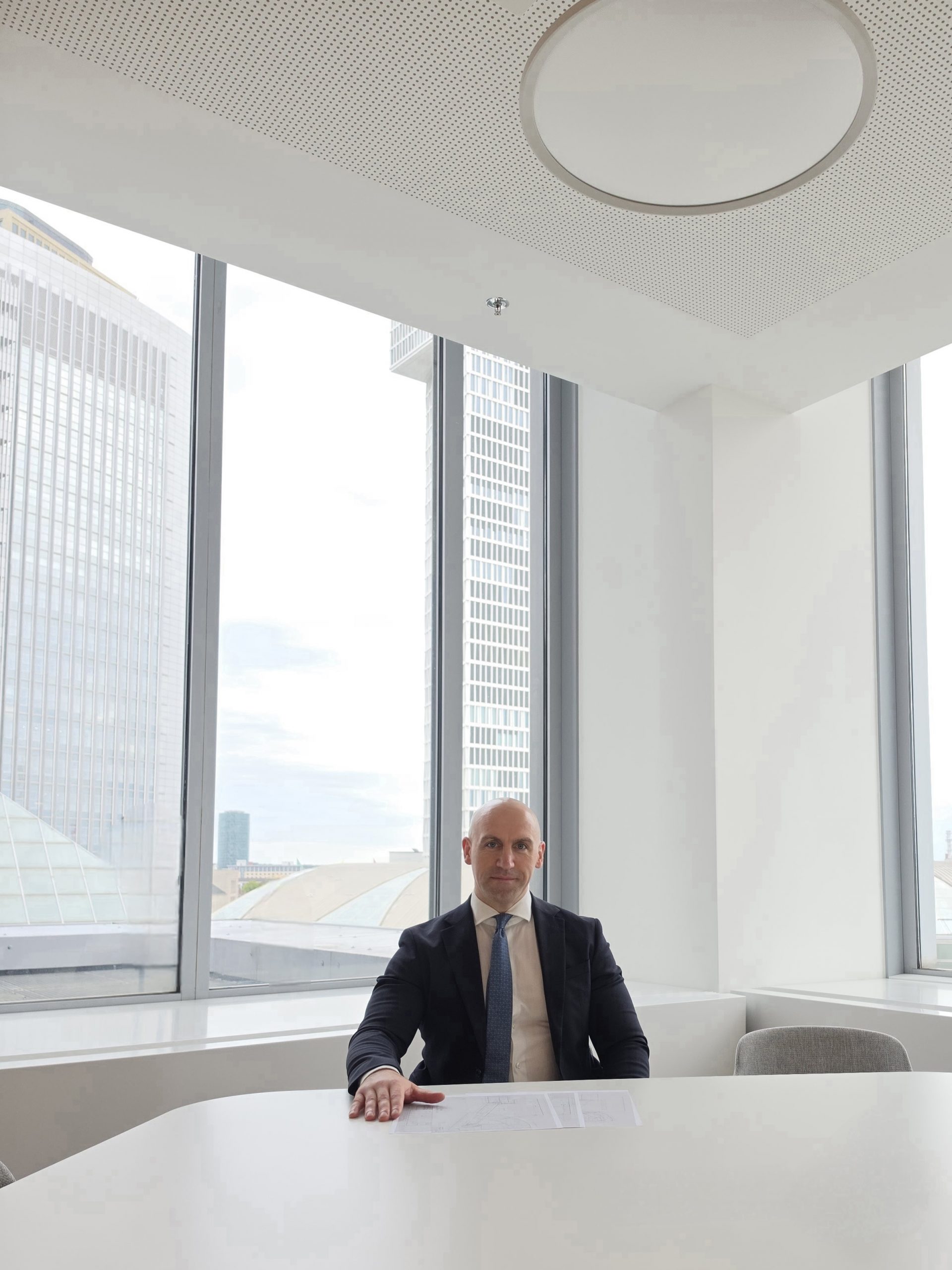 Ronny Kazyska bei der Prüfung von Objektunterlagen an einem Konferenztisch in Frankfurt am Main zum Grundsatz der Due Diligence bei Immobilientransaktionen.