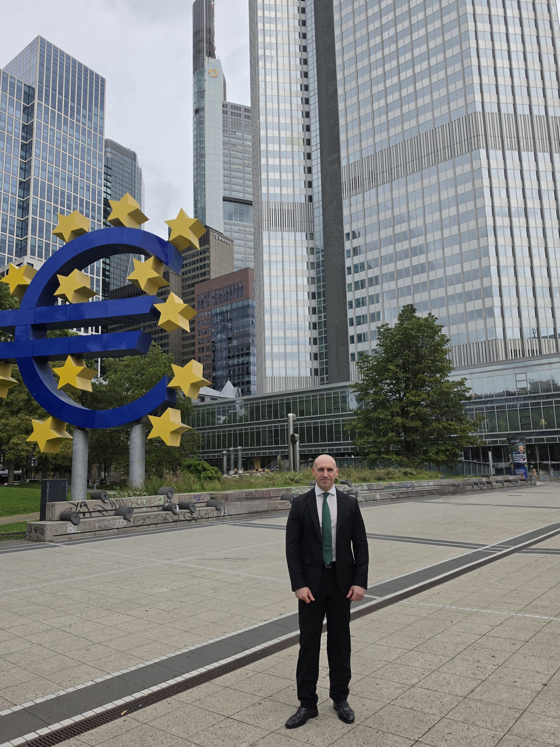 Ronny Kazyska vor dem Eurozeichen und der Frankfurter Hochhauskulisse zum Grundsatz des Zinsniveaus auf den Immobilienmärkten.