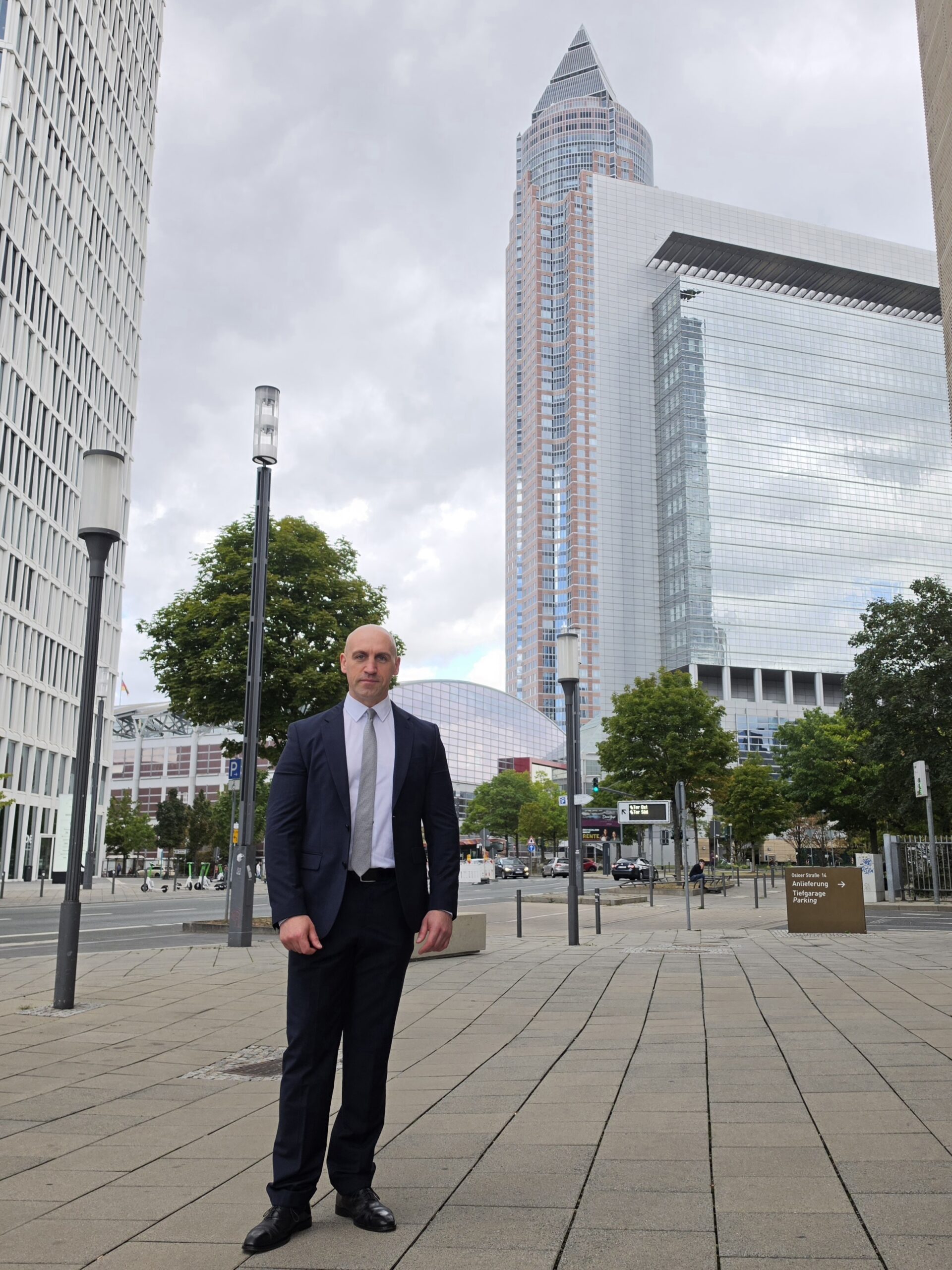 Ronny Kazyska vor dem Messeturm und moderner Büroarchitektur in Frankfurt am Main zum Grundsatz Kapitalmarkt.